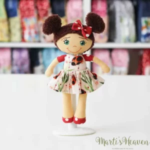 малка кукличка с тъмна коса в десен на калинки и червено на точки